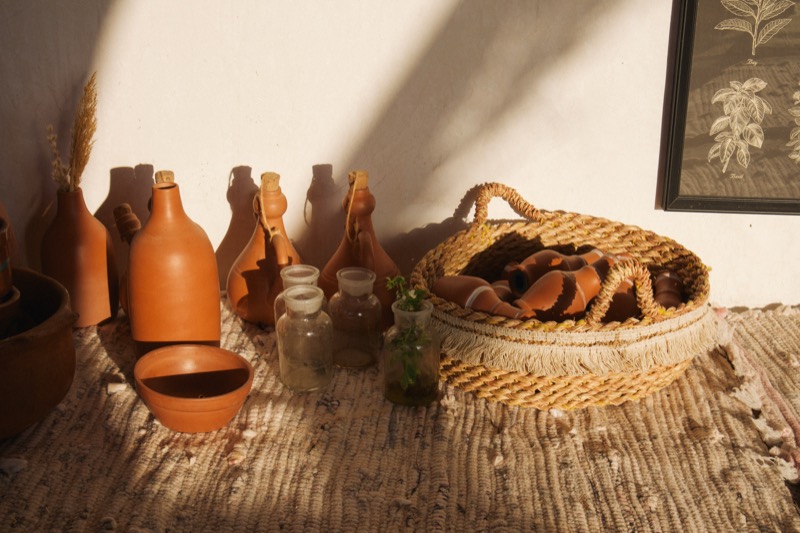 Clay jugs and a woven basket in warm afternoon light