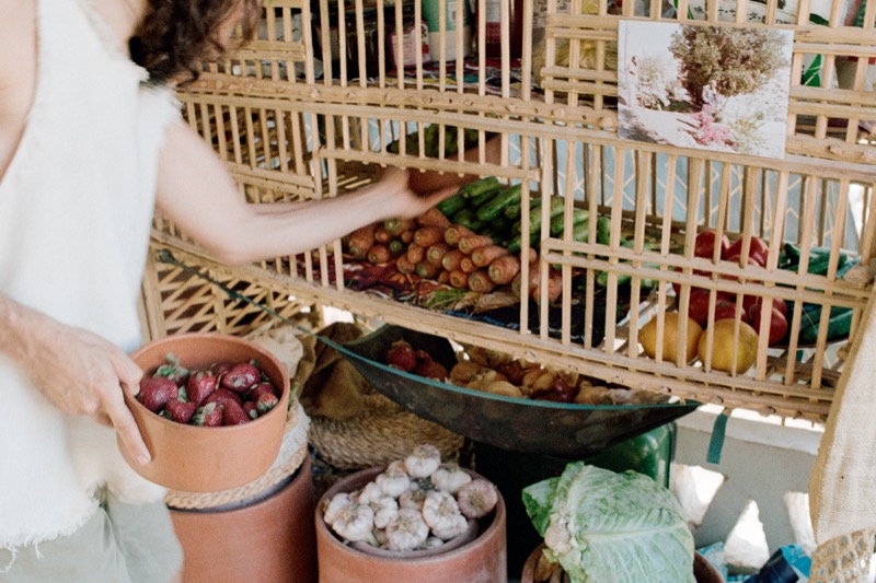 Choosing vegetables and fruit from a wooden market stand