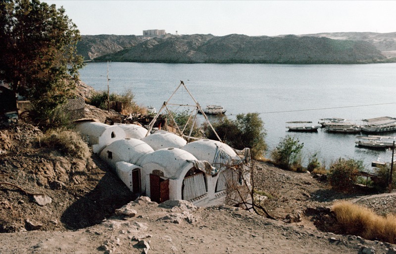 The domes and the wooden pyramid frame on the hill, boats moored on the river below