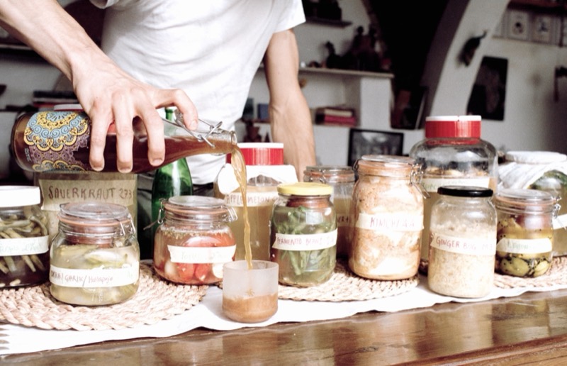 Pouring a ferment into glass jars at a workshop